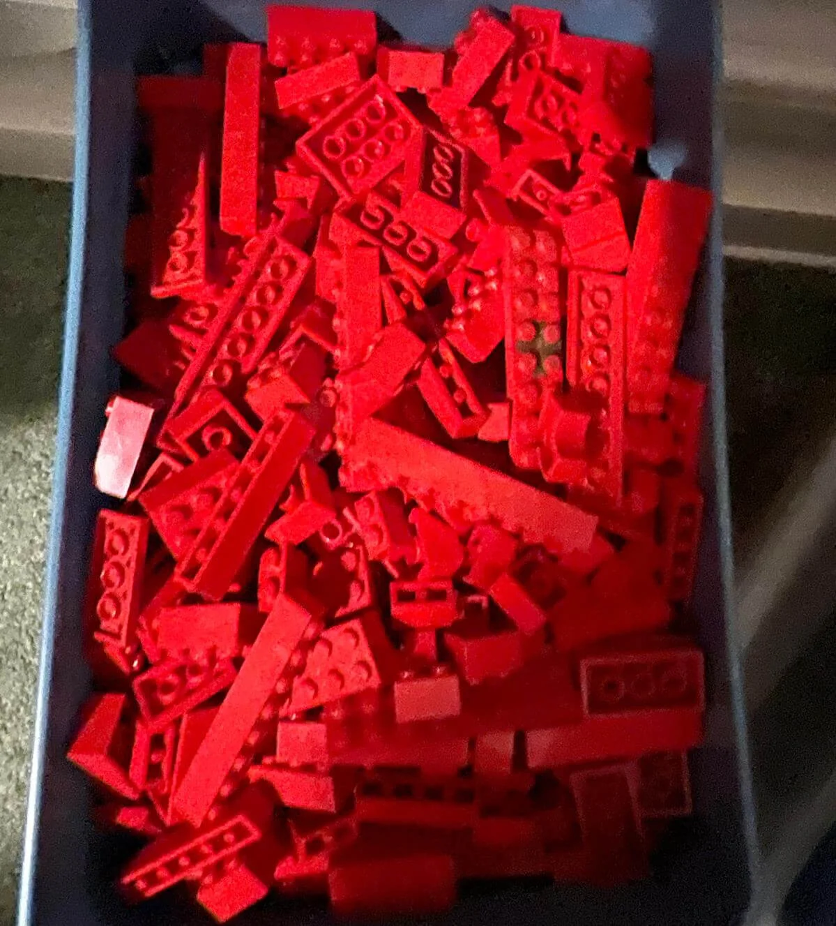 Een bakje met gesorteerde rode LEGO steentjes